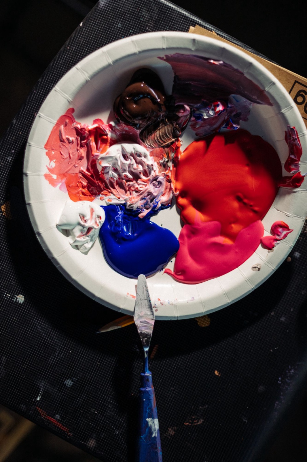 Paper plate palette with acrylic paints and a palette knife