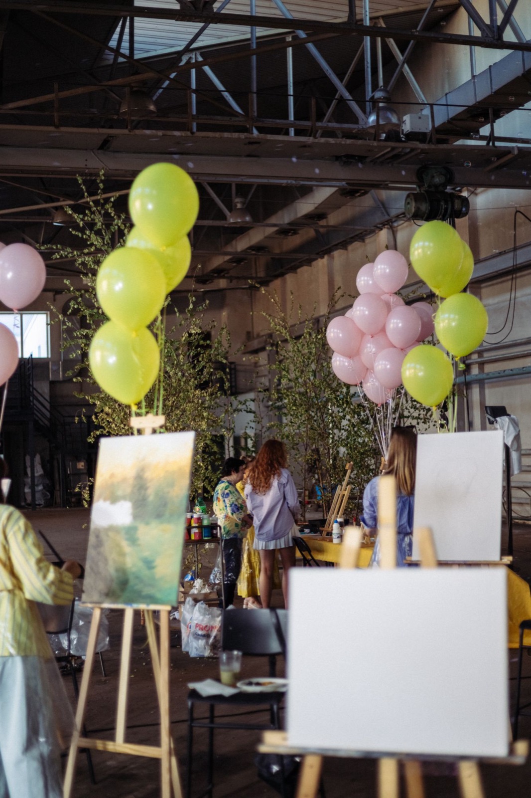 Easels, canvases and balloons set up in the industrial hall of Art Cehs