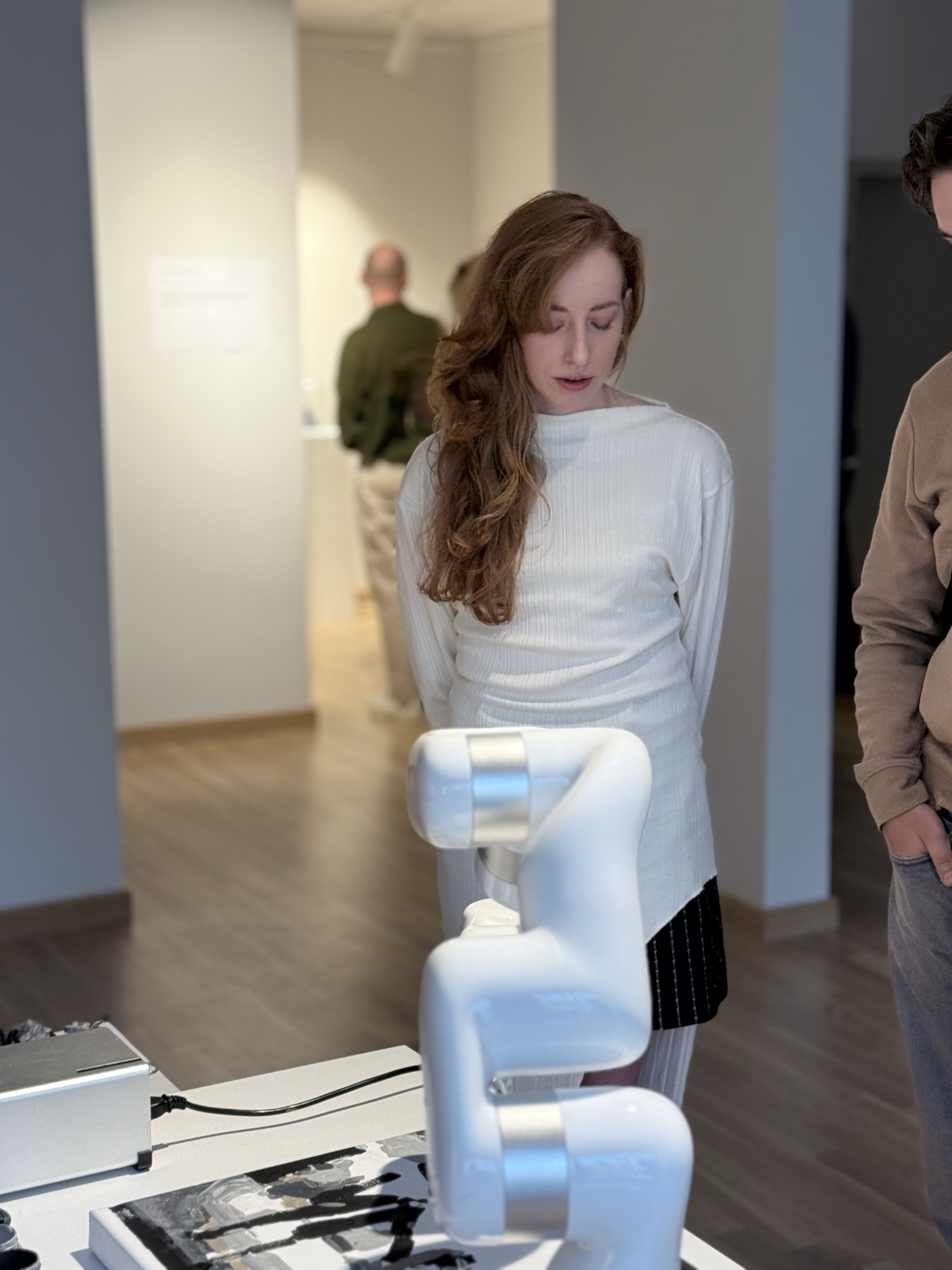 Anastasija Aleksejeva watching the robotic arm at the exhibition