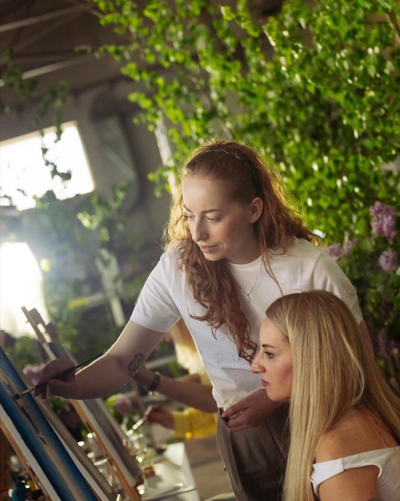 Anastasija Aleksejeva guiding a participant at the easel